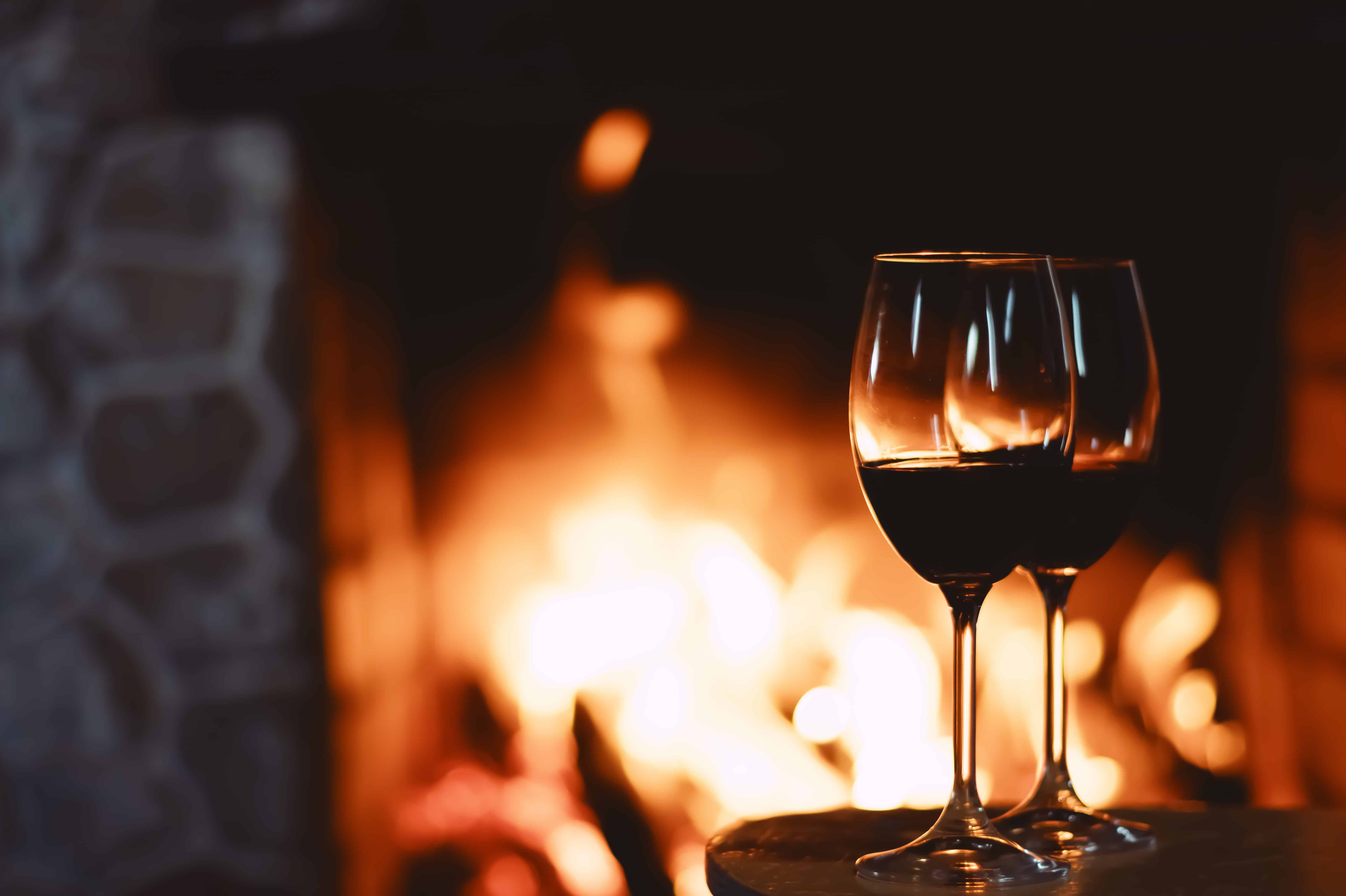 Red wine in front of a fireplace, relaxing atmosphere at home